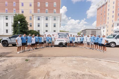 The McCuller Moving crew lined up in front of the branded trailer outside the Ole Miss residence halls