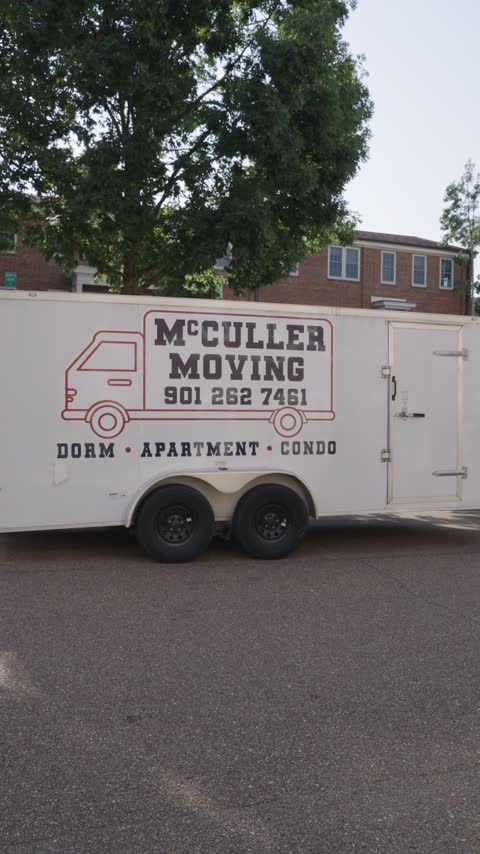 The McCuller Moving trailer with the truck logo, phone number and the words Dorm, Apartment, Condo