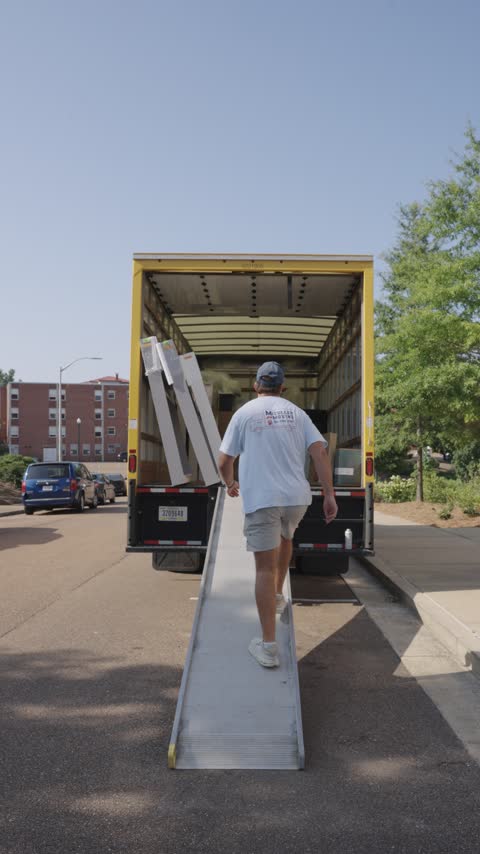 A crew member walking up the ramp into the truck for the next flat-pack box