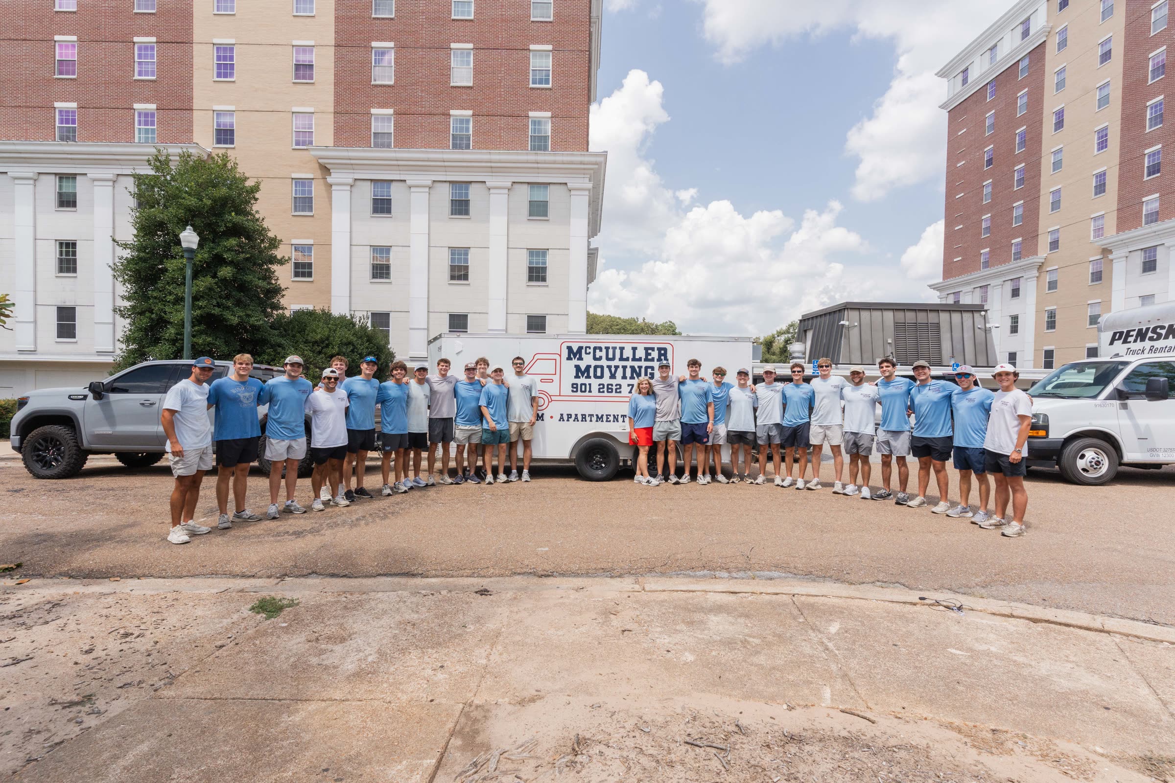 The McCuller Moving crew lined up in front of their branded trailer outside the Ole Miss residence halls